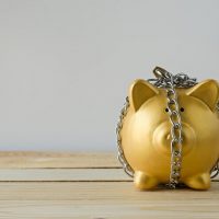 Gold piggy bank locked up in chains