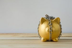 Gold piggy bank locked up in chains