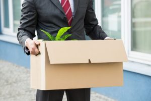 Businessman holding cardboard box moving out of office