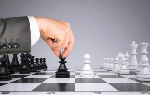 Businessman moving a pawn on a chess board