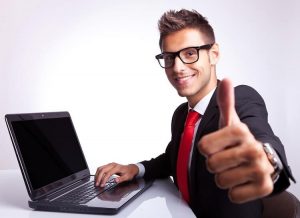 Businessman working on computer and showing thumbs up