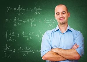 Male math teacher in front of a chalk board